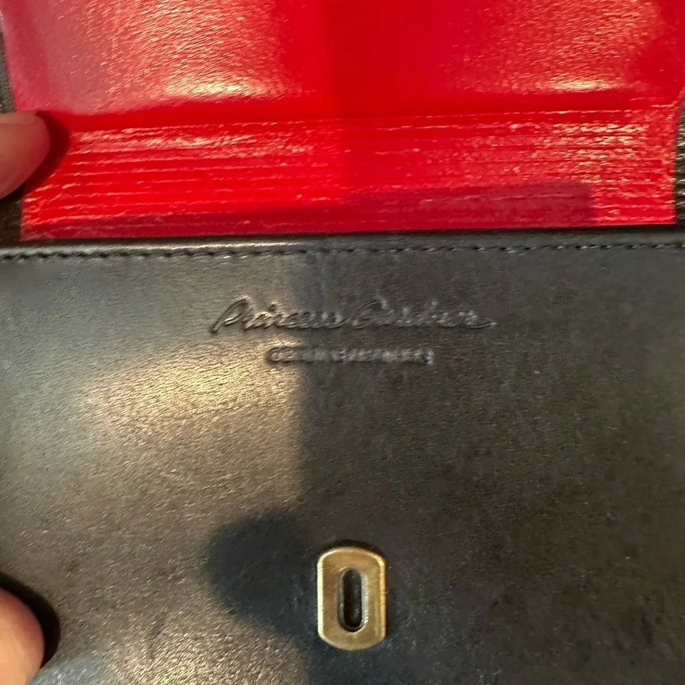 Black leather wallet with a red interior.